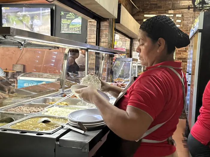 Servidora sirviendo arroz en un plato