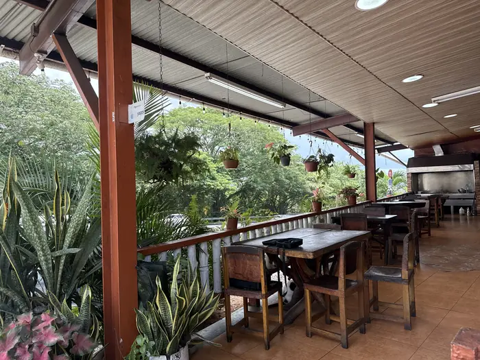 Terraza del rancho con plantas colgantes y mesas de madera