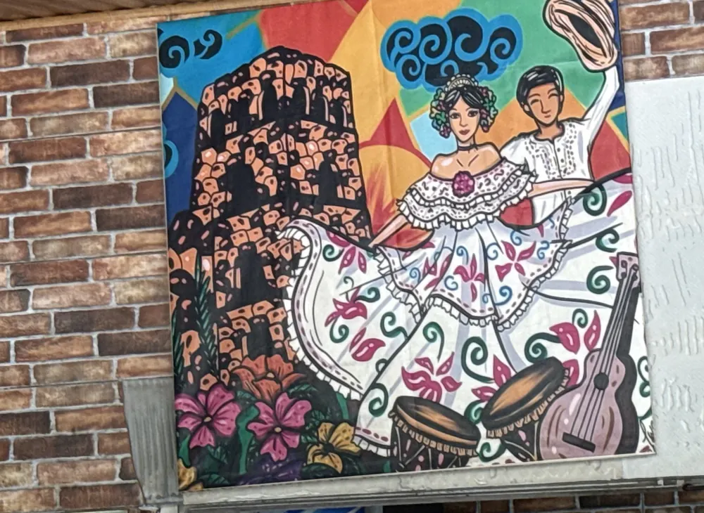 Cuadro de una pareja bailando en pollera y montuno, pintado en la pared del rancho